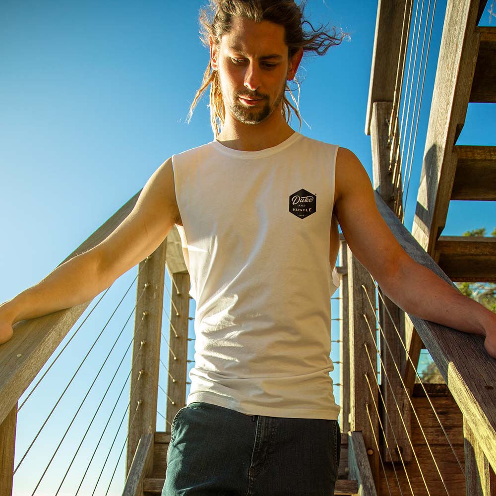 Ollie in the Men’s muscle tank, with raw arm holes, in white
